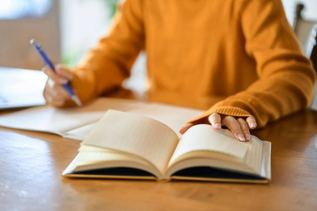 Asian woman's hand studying for qualifications