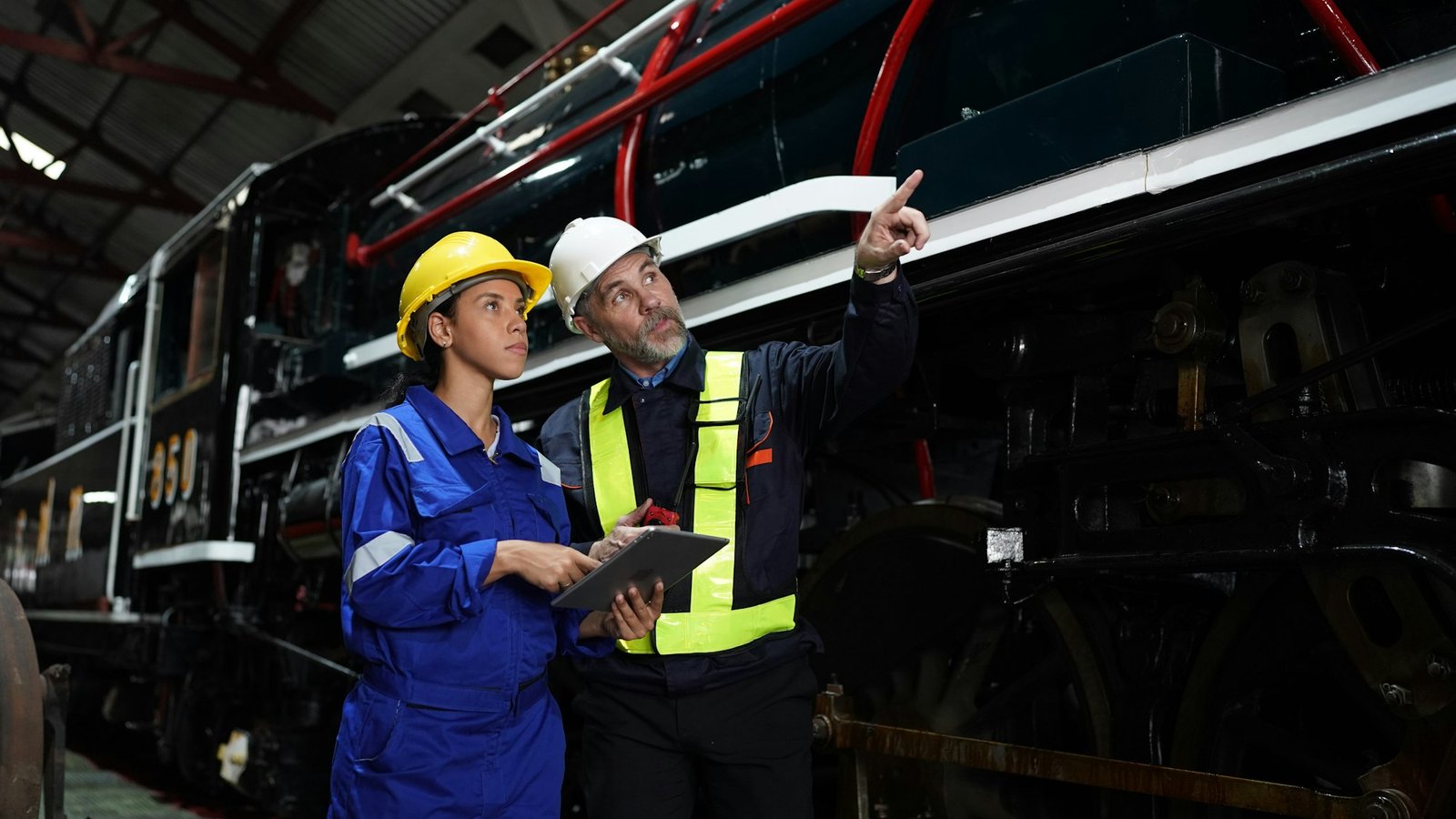 Instructor and apprentices at train in railway engineering facility. Factory indusrty Business.